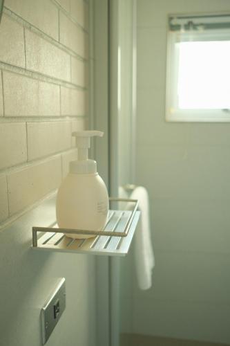 a soap dispenser sitting on a shelf in a bathroom at Maru in Tainan