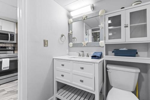 een witte badkamer met een toilet en een wastafel bij New Oceanview Suite - Caravelle 504 in Myrtle Beach