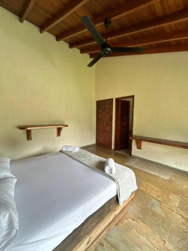 a bed in a room with a ceiling fan at Casa Fuego in La Pintada