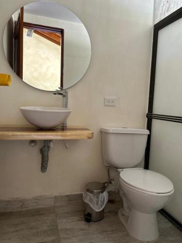a bathroom with a white toilet and a mirror at Casa Fuego in La Pintada