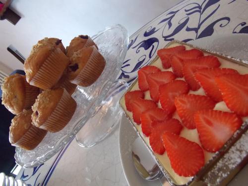 a cake with strawberries on top of it on a table at Residence Alesi in Malcesine