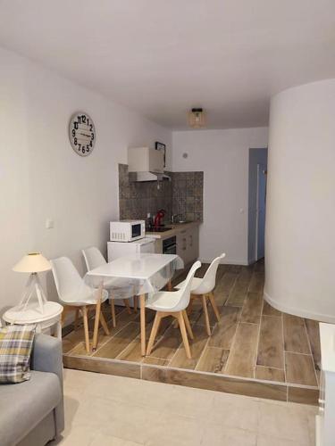 une cuisine et une salle à manger avec une table et des chaises dans l'établissement Charmant T2 au cœur de Narbonne, à Narbonne