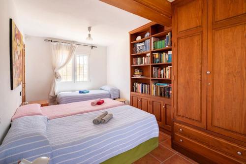 Un dormitorio con una cama y una estantería. en Villa Los Balcones, en Torrevieja
