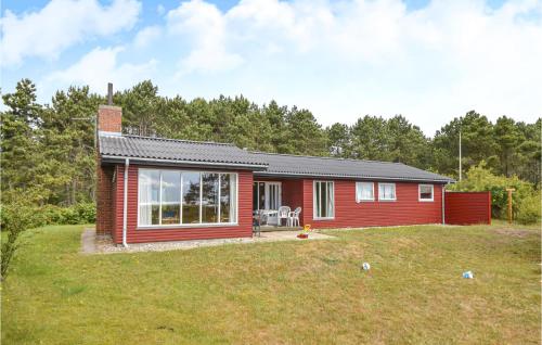 a small red house on a grass field at Mugge in Ebeltoft