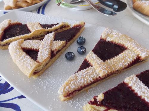 a plate with three slices of cake and blueberries at Residence Alesi in Malcesine