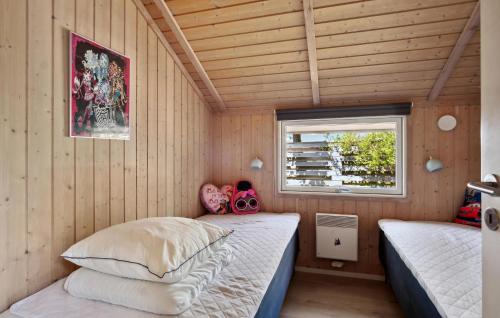 a bedroom with two beds in a room with wooden walls at Lovely Home In Skælskør With Wifi in Skælskør