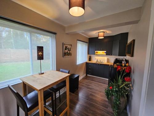 a kitchen and dining room with a table and chairs at Le DEN de Tremblant in Mont-Tremblant