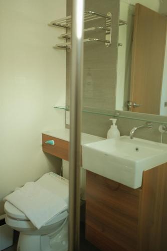 a bathroom with a sink and a toilet and a mirror at Maru in Tainan
