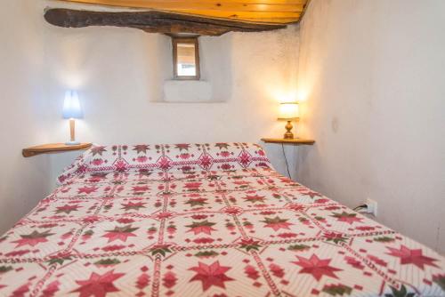 - une chambre avec un lit doté d'une couette rouge et blanche dans l'établissement Gîte Gîtes de France 6/8 pers à La Bessière, à Saint-Jean-Chazorne