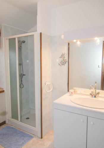 une salle de bain blanche avec une douche et un lavabo dans l'établissement Gîte Gîtes de France 6/8 pers à La Bessière, à Saint-Jean-Chazorne