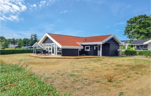 a house with a red roof and a yard at Three-Bedroom Holiday Home In Bjert in Binderup Strand