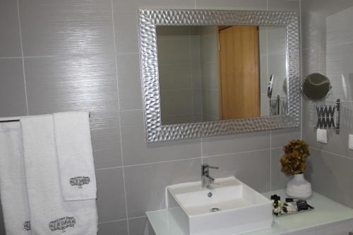 a white bathroom with a sink and a mirror at Quinta Vale de Carvalho in Pinhal do Douro