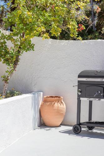 a grill and a pot sitting next to a wall at Villas Maher Two in Vasilítsion