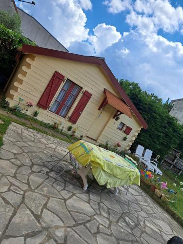une maison avec une table devant elle dans l'établissement Charmant chàlet douillet et cosy, à Vigneux-sur-Seine