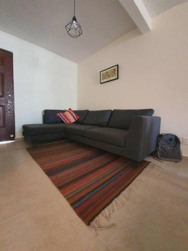 a black couch in a living room with a rug at Departamento Casa Oaxaca SMA Pool Rooftgarden in San Miguel de Allende