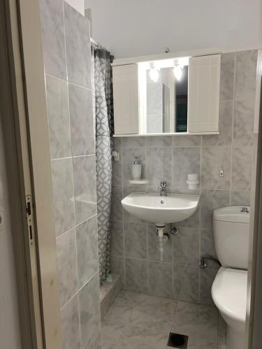 a bathroom with a sink and a toilet at Vino suites in Agia Anna Naxos