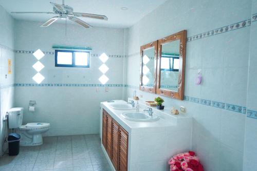 a bathroom with a sink and a toilet at Royal Adobe Pool Villa in Jomtien Beach