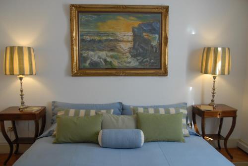 a blue bed with two lamps and a painting on the wall at Casa Fracasso in Verona