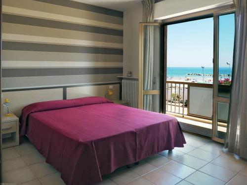 a bedroom with a bed and a view of the ocean at Hotel Velus in Civitanova Marche