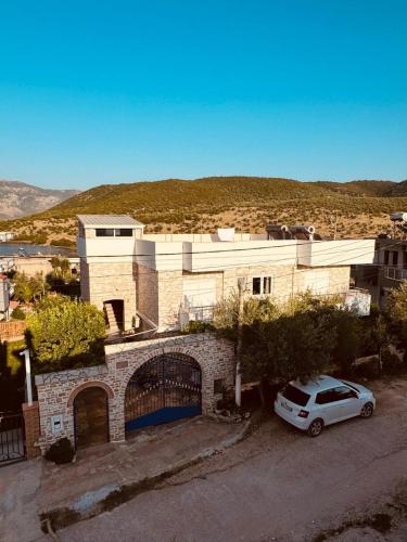 a white car parked in front of a building at Orfeu apartments Ksamil in Ksamil