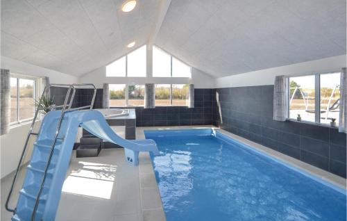 a swimming pool with a blue slide in a bathroom at Lovely Home In Grenaa With Sauna in Grenå