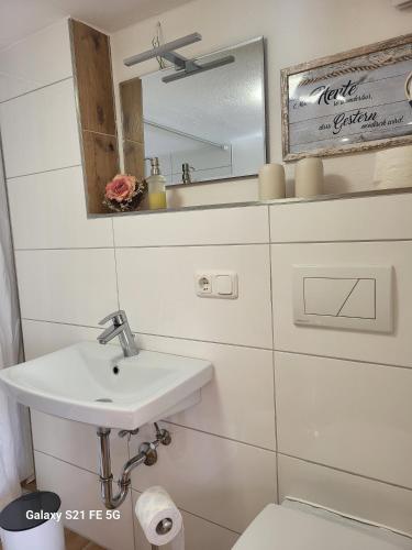 a white bathroom with a sink and a mirror at Ferienhof Müller Vorderburg in Vorderburg