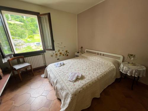 a bedroom with a bed and a large window at PANORAMA,Cremia-casa LUISA in Cremia