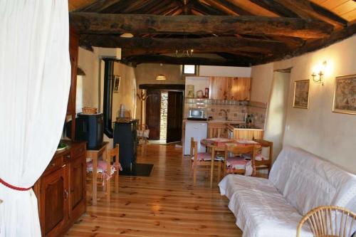 a living room with a couch and a kitchen at Gîte Maison Cavalier 2/4 personnes à Gabriac in Gabriac