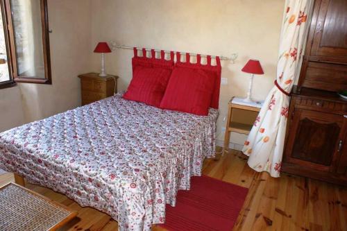 a bedroom with a bed with red pillows at Gîte Maison Cavalier 2/4 personnes à Gabriac in Gabriac
