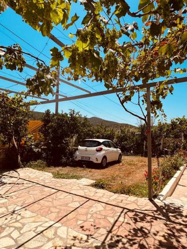 a white car is parked in a driveway at Orfeu apartments Ksamil in Ksamil