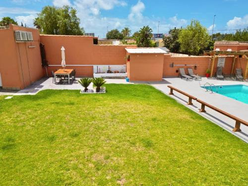 podwórko z trawnikiem i basenem w obiekcie Apartamento con Piscina ADULTS ONLY w mieście Chiclana de la Frontera
