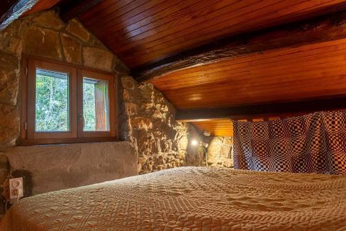 une chambre avec un grand lit avec un plafond en bois dans l'établissement Gîte La Grange, Gîtes de France 2/4 personnes à la Caze, à Saint-Pierre-des-Tripiers