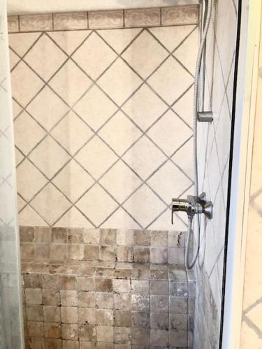 une douche avec une porte vitrée dans une salle de bain dans l'établissement le Pijeonnier, à Bédoin