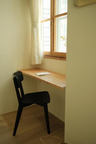 a desk with a chair and a window at Maru in Tainan
