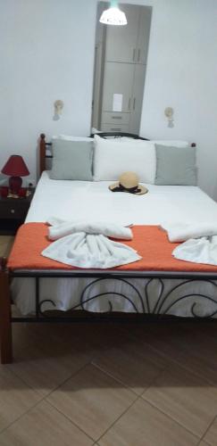 a bedroom with a bed with a hat on it at Marena 1 in Makry Gialos