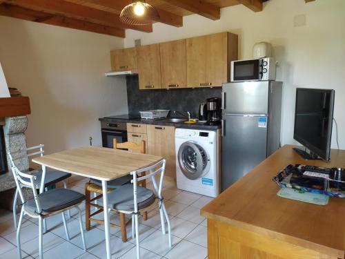 une cuisine avec une table et un réfrigérateur dans l'établissement Gîte Gîtes de France 3/4 personnes à Ferluguet, à Sainte-Eulalie