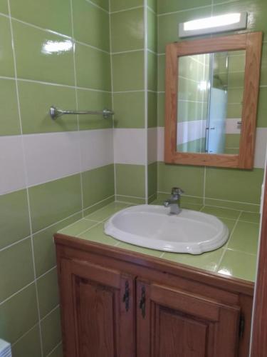 une salle de bain avec un lavabo et un miroir dans l'établissement Gîte Gîtes de France 3/4 personnes à Ferluguet, à Sainte-Eulalie
