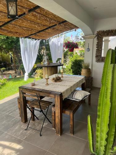 une table à manger et des chaises sous un parasol dans l'établissement Le flamant rose, à Ensuès-la-Redonne