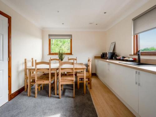 a kitchen and dining room with a table and chairs at Loch Ness Clansman Hotel in Drumnadrochit