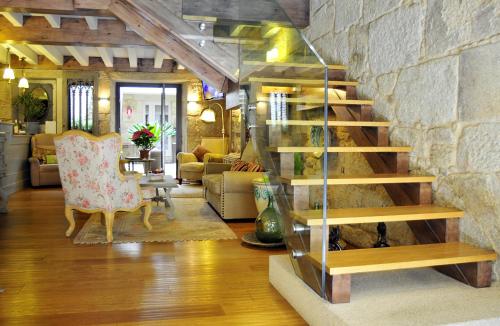 sala de estar con escalera y pared de piedra en Hotel Real Cambados, en Cambados