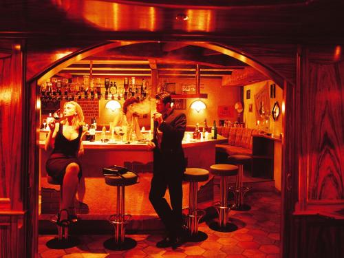a man and a woman sitting at a bar at Landgasthof Jagerwirt in Volders