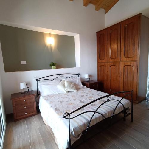 a bedroom with a bed and a wooden cabinet at Castello Mountain Lake Iseo Hospitaty in Bossico