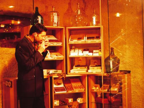a man standing in front of a display of wine bottles at Landgasthof Jagerwirt in Volders