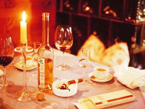 a table with a bottle of wine and wine glasses at Landgasthof Jagerwirt in Volders