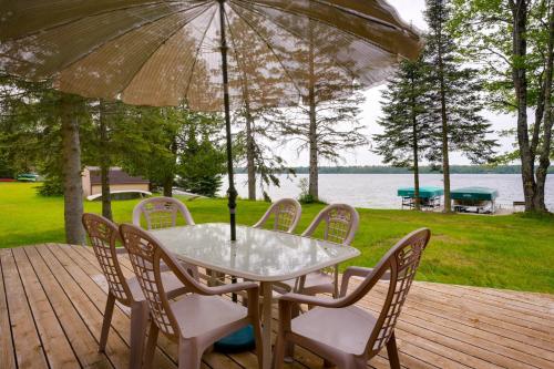 a table and chairs on a deck with an umbrella at The Loony Bin in Manitowish Waters