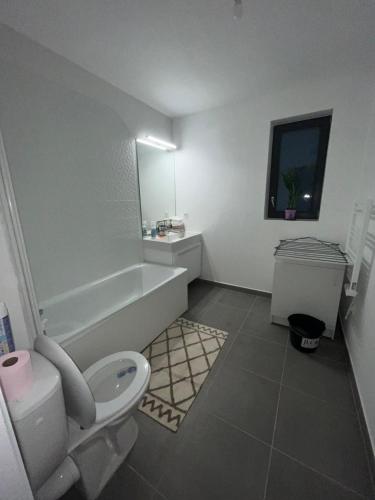 a bathroom with a toilet and a tub and a sink at Appartement de DJ à Chanteloup-en-brie in Chanteloup-en-Brie