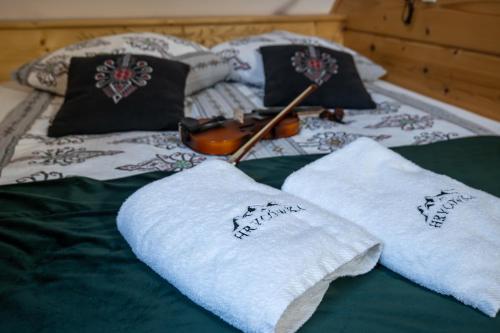 a bed with towels and a guitar on it at HRYCÓWKA Domki z Widokiem in Grywałd
