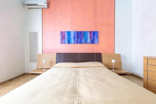 a large bed in a room with a painting on the wall at Casa Tonio by BarbarHouse in Taviano