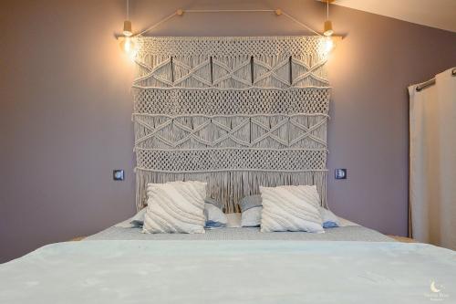 a bedroom with a bed with a headboard and two pillows at Les Pins Perdus in Saint-Ciers-dʼAbzac