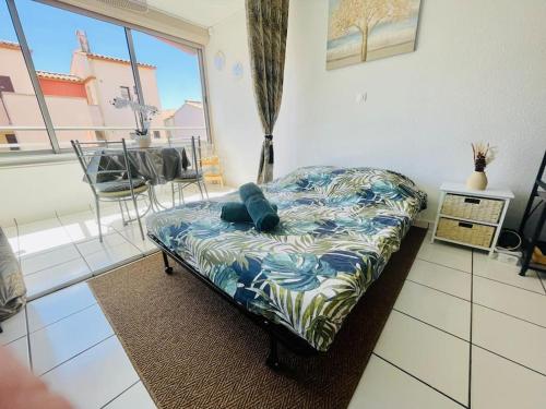 - un petit lit dans une chambre dotée d'une grande fenêtre dans l'établissement Cap Studio Parking Wifi Port Plage, au Cap d'Agde